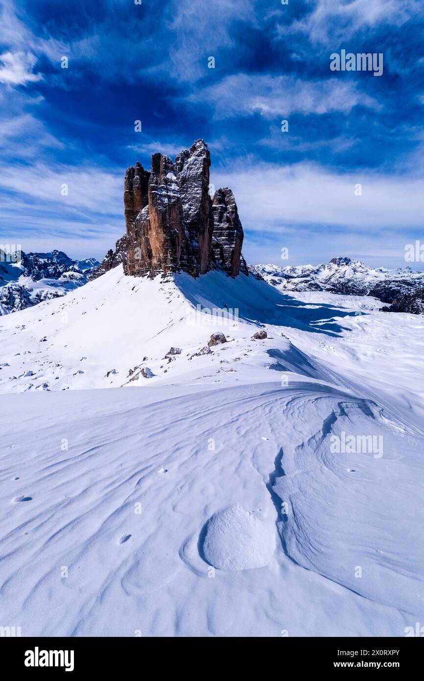 Ciaspolate che creano strutture artistiche nel Parco naturale delle tre Cime in inverno, le cime delle tre Cime di Lavaredo in lontananza, viste da forcella Lavar Foto Stock