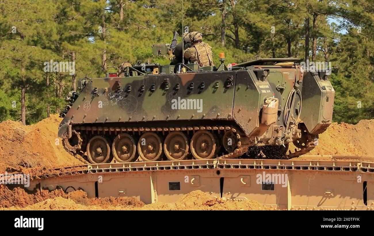Un M113 Armored Personnel Carrier, assegnato al 1st Armored Brigade Combat Team, rompe un fossato di carri armati usando un Joint Assault Bridge (JAB), durante Marne Focus a Fort Stewart, Georgia, 12 aprile 2024. Marne Focus è una componente chiave degli sforzi della divisione per formare e equipaggiare le forze per mantenere il nostro vantaggio competitivo e combattere e vincere in conflitto. (Foto U.S. Army di PFC. Santiago Lepper) Foto Stock