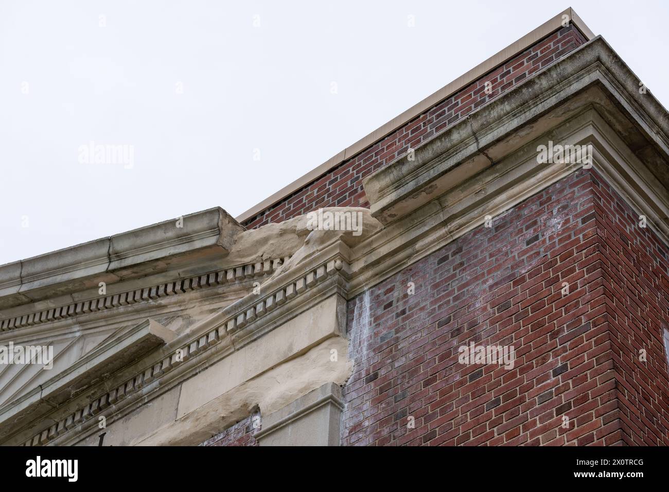 Esempio di elementi in cemento prefabbricato ornamentale in rovina, elementi in un vecchio edificio scolastico in mattoni. Foto Stock