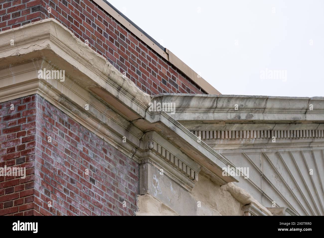 Esempio di elementi in cemento prefabbricato ornamentale in rovina, elementi in un vecchio edificio scolastico in mattoni. Foto Stock