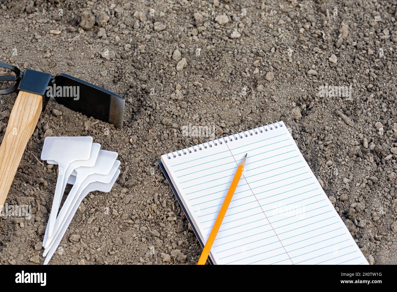 Pianificazione del giardino con notebook, palo segnaletico per piante e attrezzi per giardinaggio. Giardinaggio, prodotti biologici e concetto di giardino domestico. Foto Stock Pianificazione del giardino con notebook, palo segnaletico per piante e attrezzi per giardinaggio. Giardinaggio, prodotti biologici e concetto di giardino domestico. Foto Stock