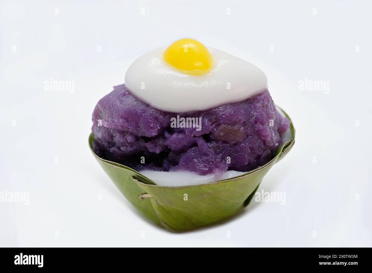Primo piano di un dessert tailandese Khanom Tako "capovolto", con salsa di taro viola e un ginkgo giallo con crema di cocco "Sunny-side up" Foto Stock