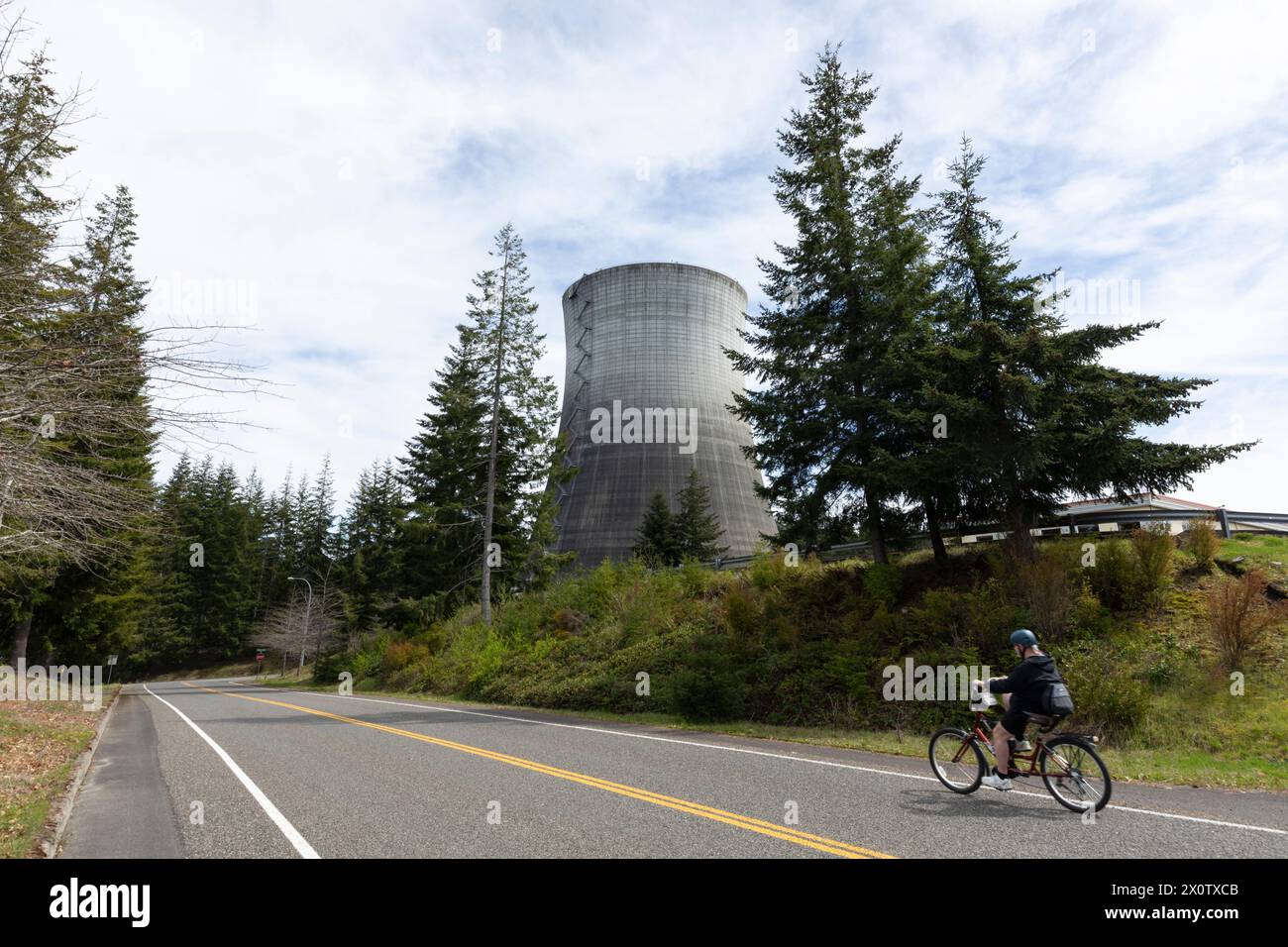 Sabato 13 aprile 2024, un ciclista passa accanto alla torre di raffreddamento della centrale nucleare dismessa di Satsop a Elma Washington. Il Washington N Foto Stock