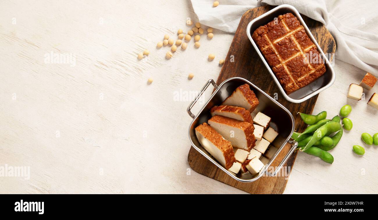 Cibo di soia. Tofu al forno su tavola, semi di soia. Prodotto vegano. Vista dall'alto, spazio copia, banner Foto Stock