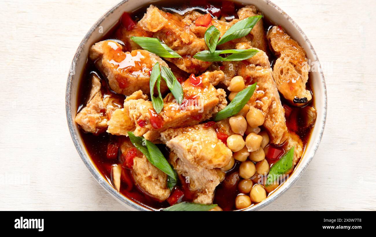 Soia con carne di soia, cipolla e tofu su sfondo di legno chiaro. Cibo vegano. Vista dall'alto Foto Stock