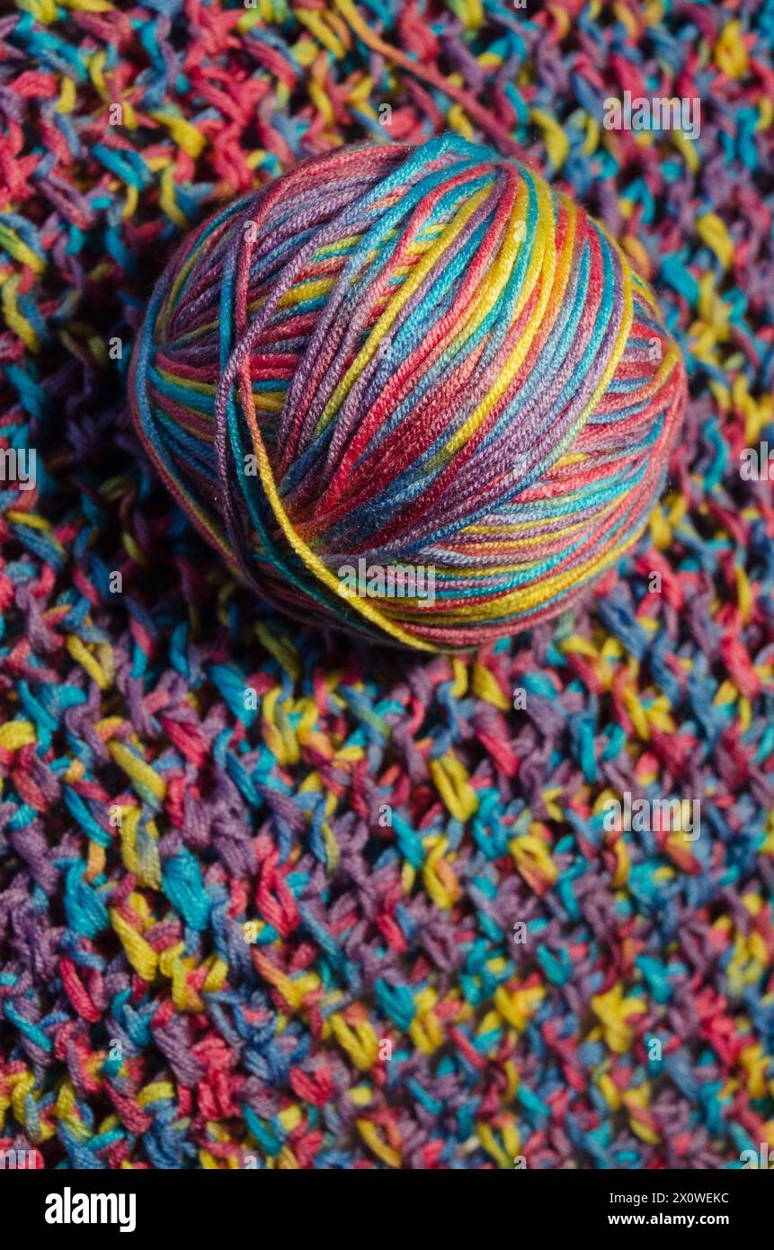 Palla di lana multicolore su una coperta all'uncinetto Foto Stock
