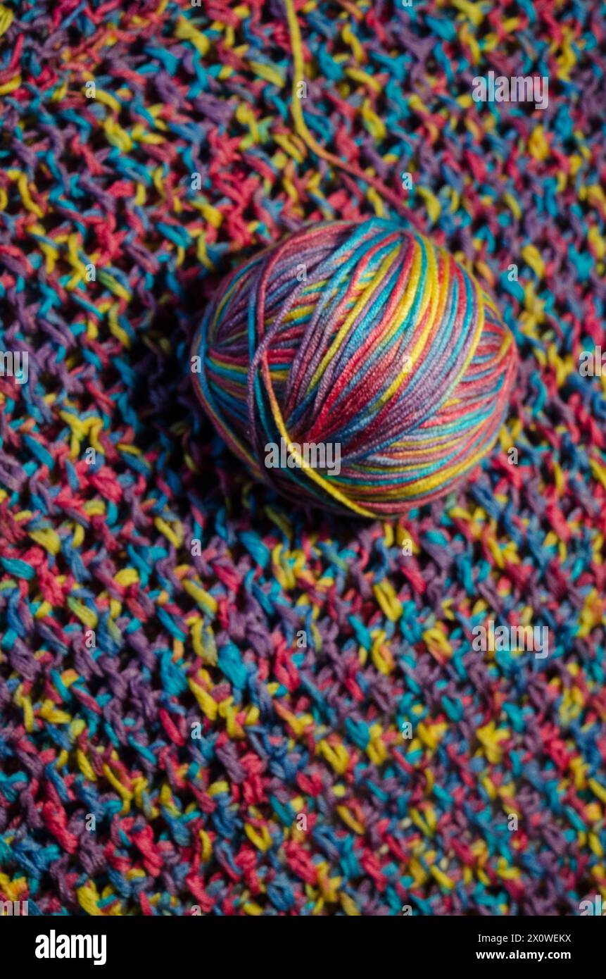 Palla di lana multicolore su una coperta all'uncinetto Foto Stock