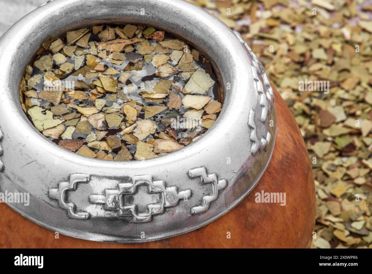 Mate Tea in un tipico calabash sudamericano, con foglie secche accanto Foto Stock