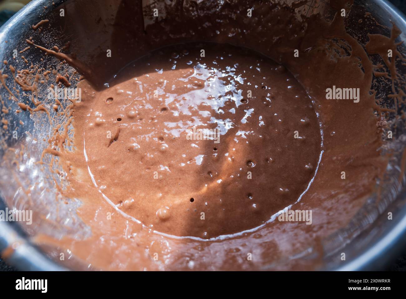 Primo piano del mix di cupcake al cioccolato all'interno del recipiente di miscelazione in metallo. Foto Stock