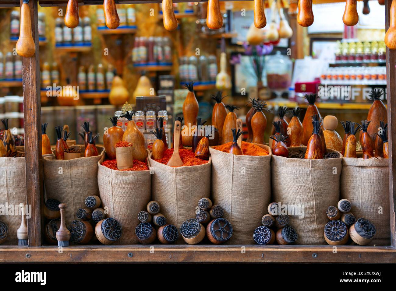 Sacchetti pieni di varie spezie multicolori e tradizionale saltshaker di legno come souvenir in una bancarella del mercato. Bukhara, Uzbekistan, Asia centrale Foto Stock
