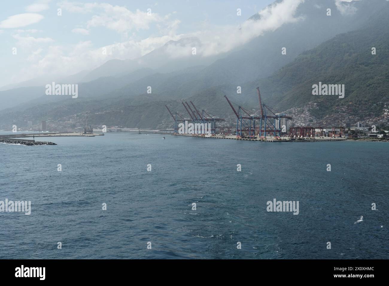 Moderno terminal container con gru a cavalletto nel porto di la Guaira osservato dalla nave da carico che si avvicina ai rivestimenti venezuelani. Foto Stock