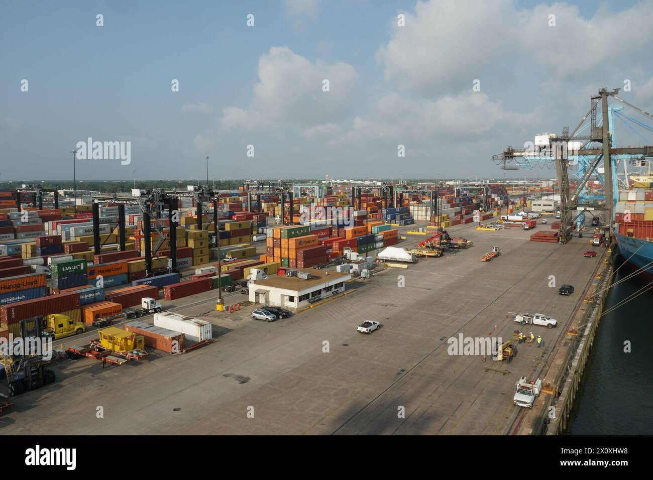 Terminal container di Houston con gru a cavalletto verdi azionate da stevedores pronti per il trasporto merci. Foto Stock
