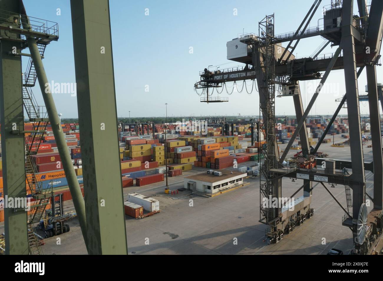 Le gru a cavalletto verdi gestite da stevedores nel terminal container di Houston sono pronte per il trasporto merci. Foto Stock