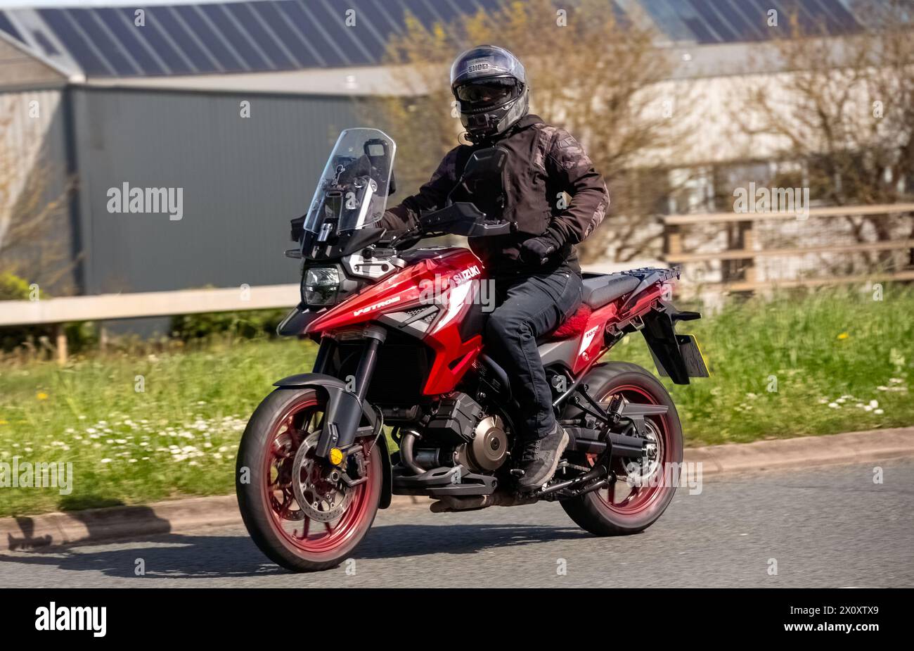 Milton Keynes, Regno Unito - 14 aprile 2024: 2023 rosso Suzuki DL 1050 rr m3 V-Strom moto che viaggia su una strada britannica Foto Stock