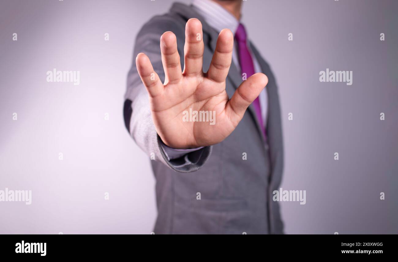 l'uomo d'affari mostra un segnale di stop, tenendosi per mano in aria. Sfondo bianco Foto Stock