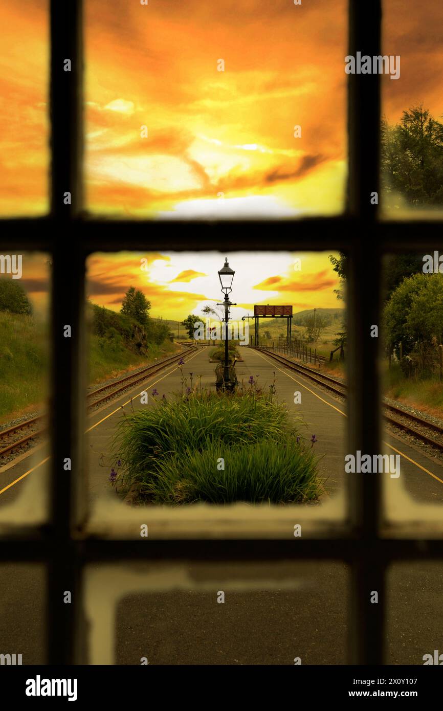 Stazione ferroviaria a scartamento ridotto Rhyd DDU attraverso una finestra al tramonto. Parte della Welsh Highland Railway nel Parco Nazionale di Eryri Foto Stock