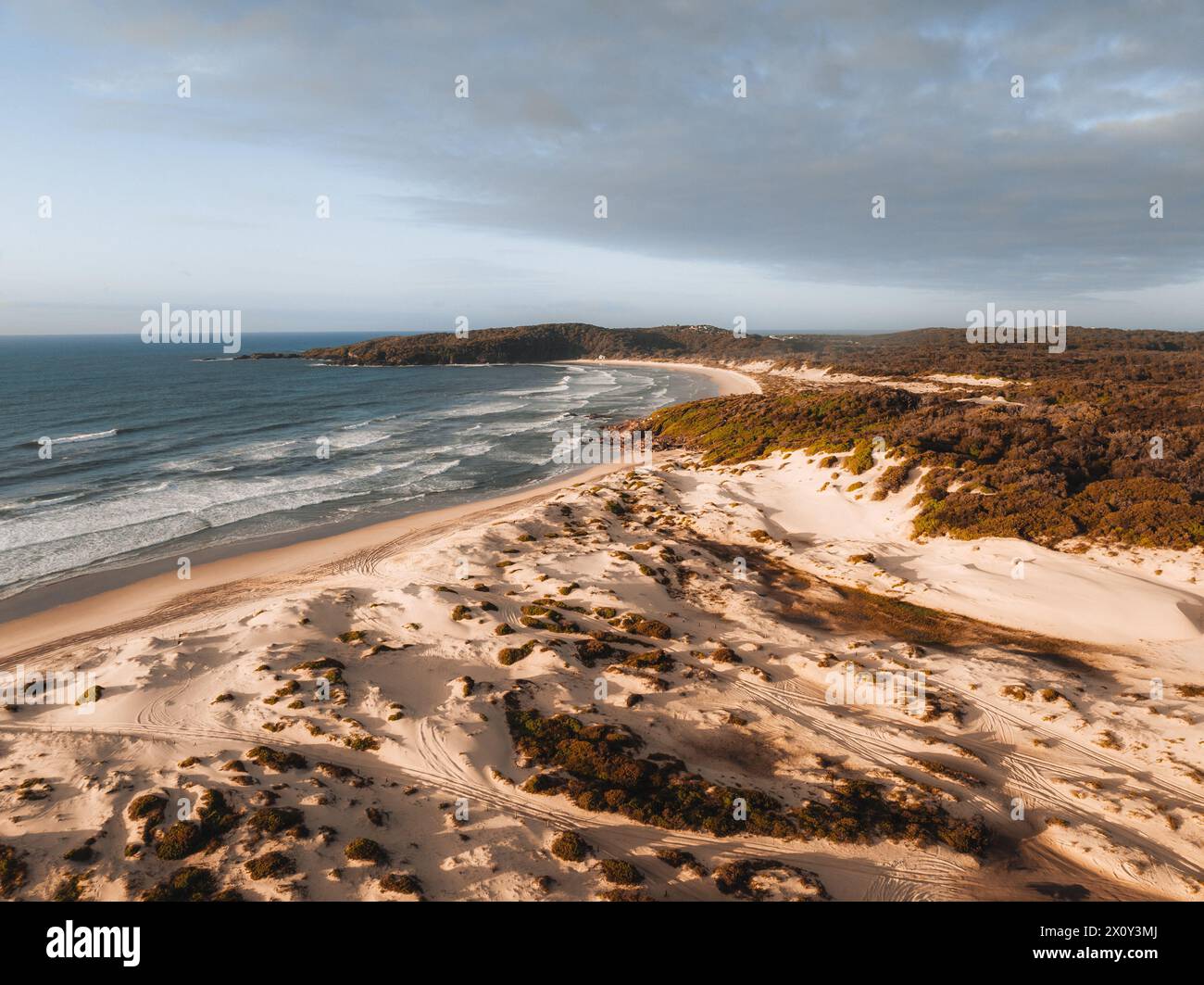 Vista aerea del drone sulla spiaggia di un miglio durante l'alba al tramonto con dune di sabbia. Forster, grandi Laghi, Australia Foto Stock