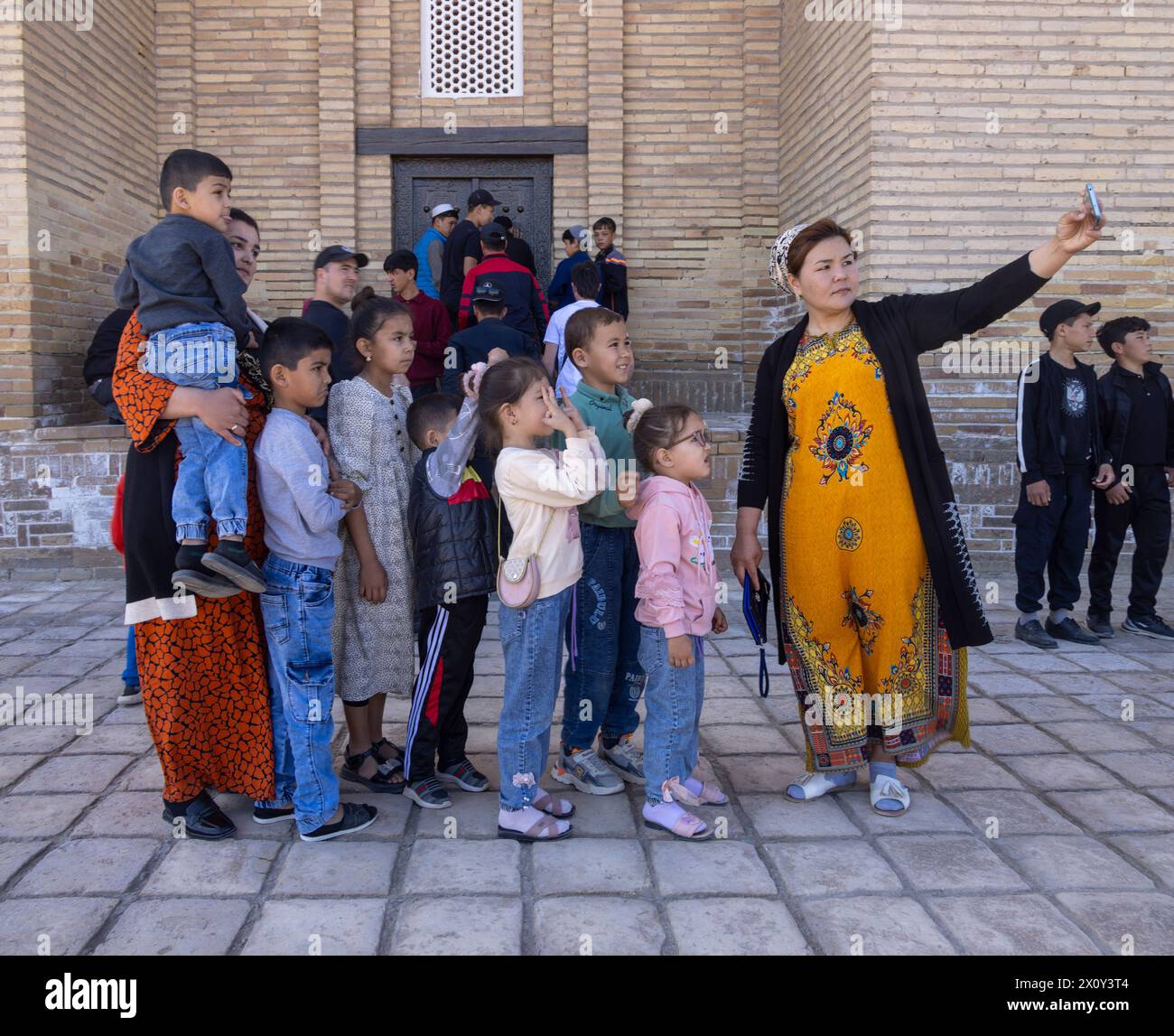 Donna che prende selfie con la famiglia, Koneurgench, Turkmenistan Foto Stock