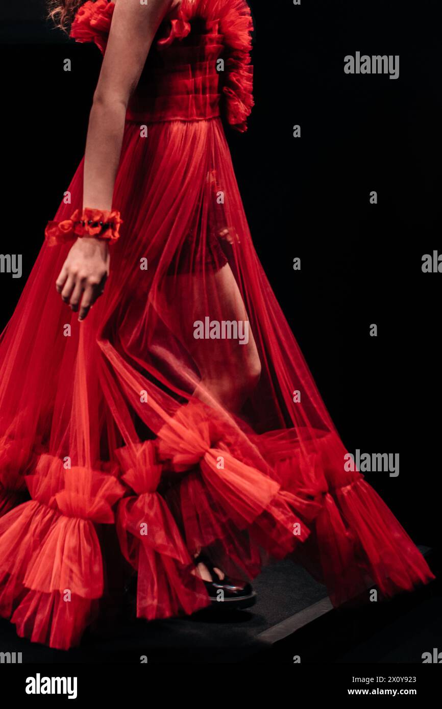 Eleganti dettagli di un lussureggiante abito da sera in organza rossa su una figura femminile su sfondo nero. Abiti eleganti e femminili Foto Stock