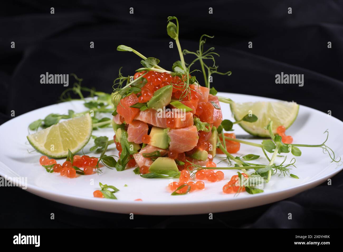 Tartare di avocado con salmone, caviale rosso e germogli di piselli. Foto Stock