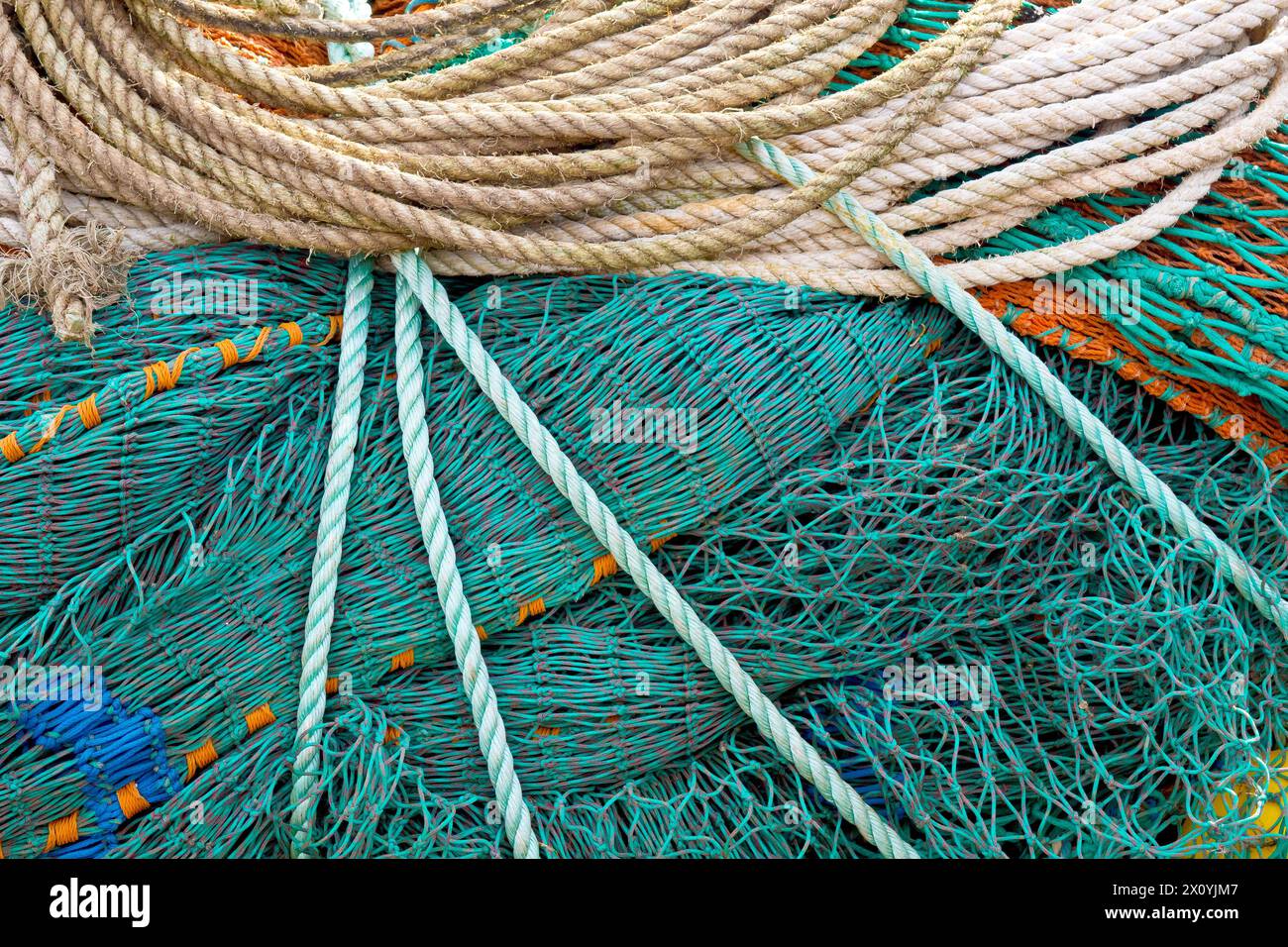 Primo piano di reti e corde utilizzate nell'industria della pesca impilate ordinatamente sulla banchina del porto di Arbroath. Foto Stock