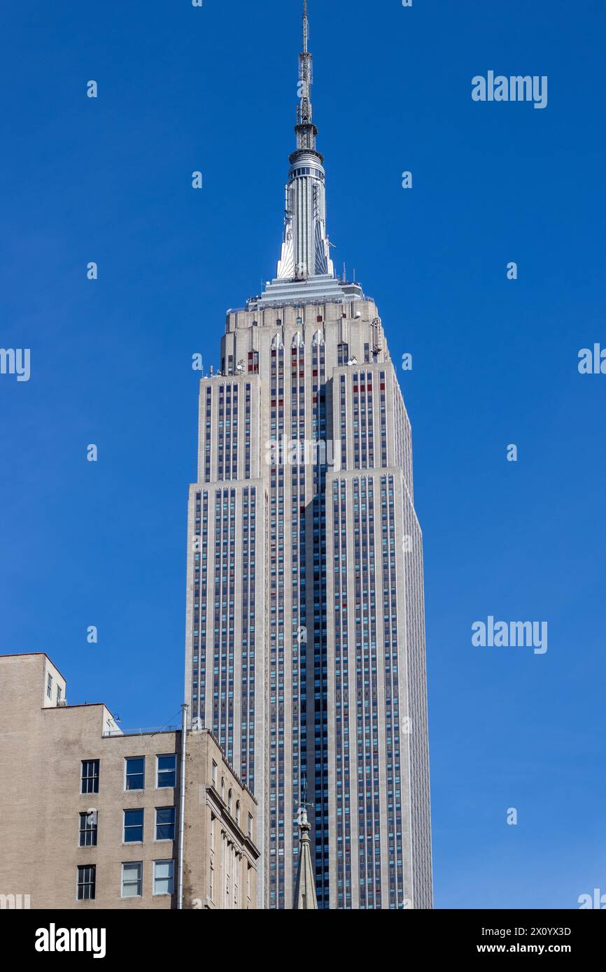 L'esterno dell'Empire State Building è esposto alla luce del sole e si affaccia su un cielo blu Foto Stock