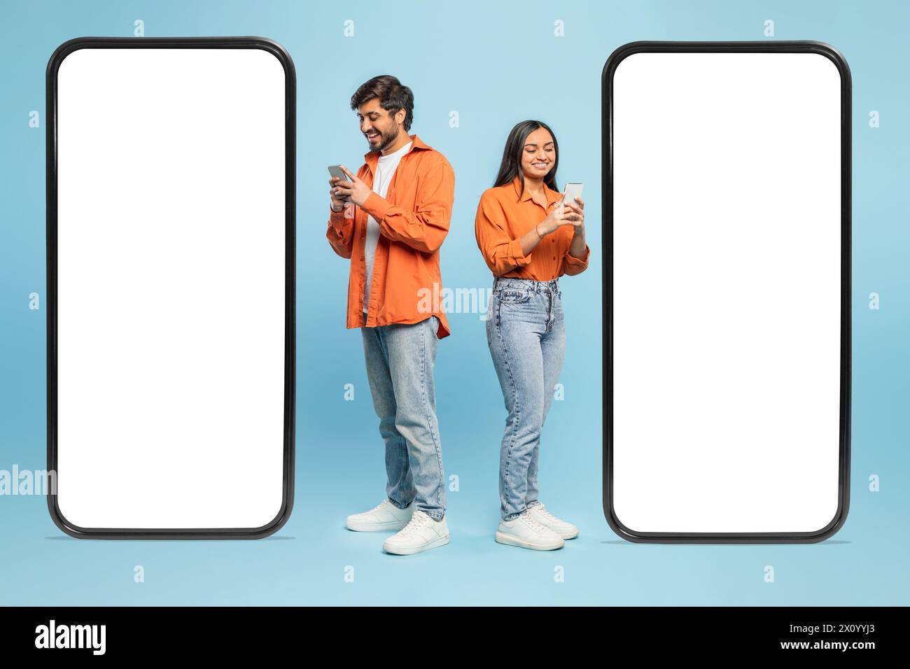 Modello di smartphone con coppia che utilizza telefoni su sfondo blu Foto Stock