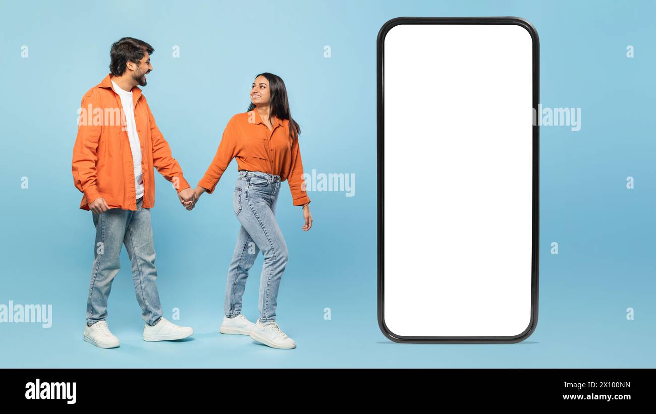 Smartphone con coppia che tiene le mani sullo sfondo Foto Stock