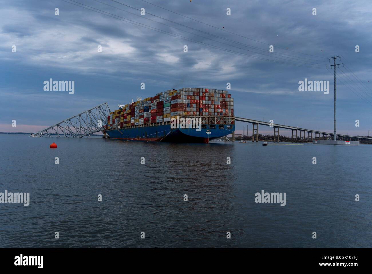 Dundalk, Stati Uniti d'America. 26 marzo 2024. La portaerei MV Dali incastrata nelle capriate d'acciaio del crollato Francis Scott Key Bridge sul canale di Fort McHenry al primo semaforo, il 26 marzo 2024, vicino a Dundalk, Maryland. Il ponte fu colpito dalla nave portacontainer di 984 piedi la mattina presto del 26 marzo e crollò uccidendo sei lavoratori e chiudendo il porto di Baltimora. Crediti: Dave Adams/USACE/Alamy Live News Foto Stock