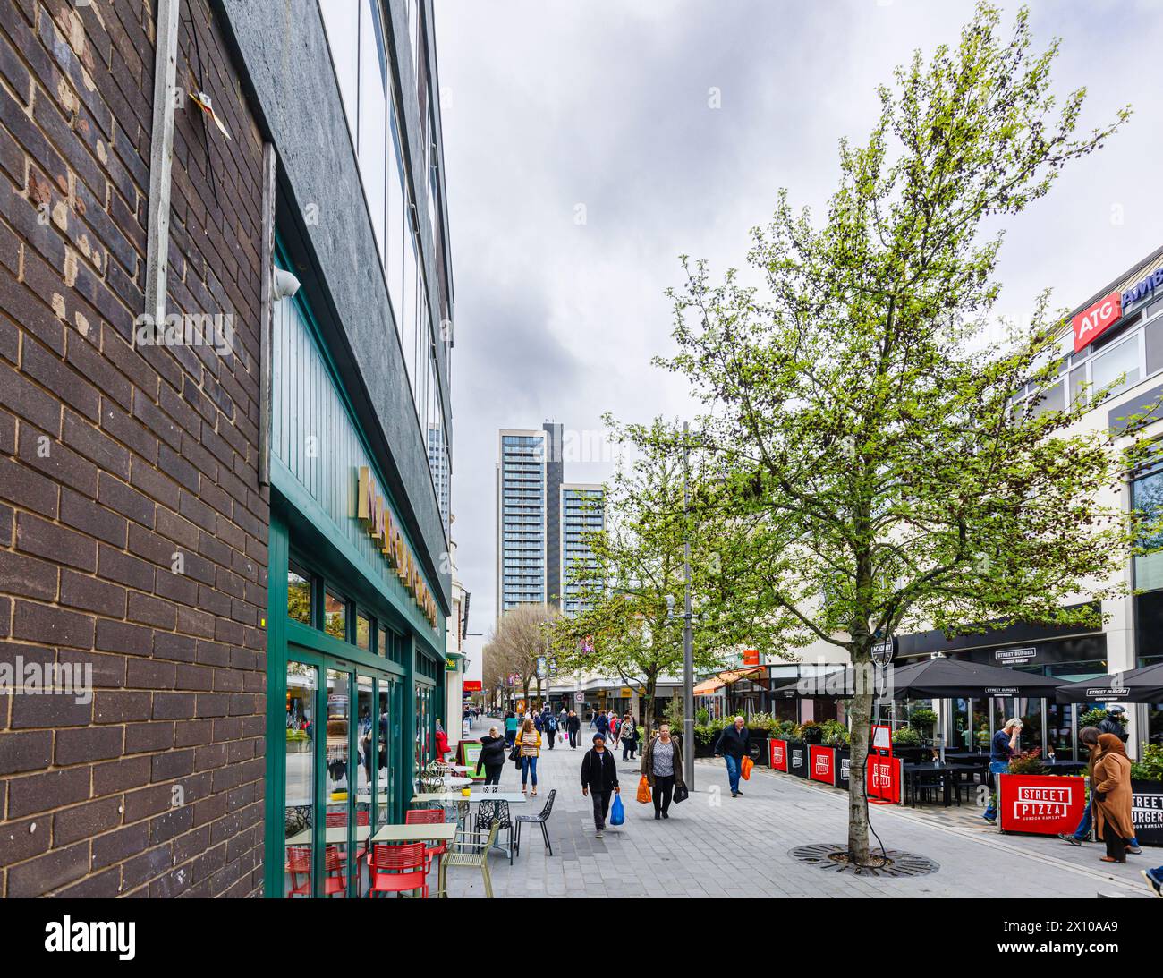 Via commerciale con negozi e ristoranti nel centro pedonale di Woking, una città nel Surrey, in Inghilterra Foto Stock