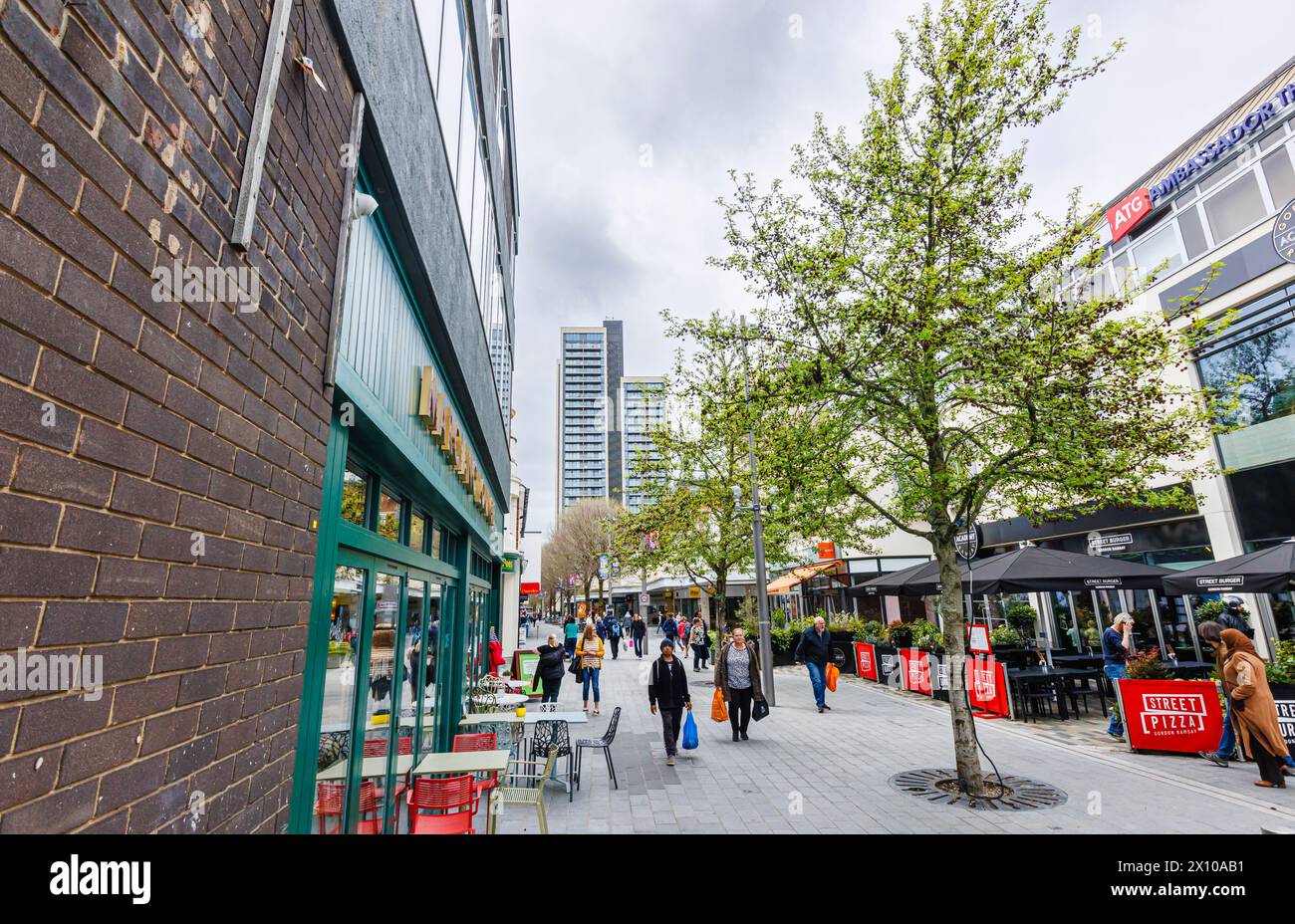 Via commerciale con negozi e ristoranti nel centro pedonale di Woking, una città nel Surrey, in Inghilterra Foto Stock