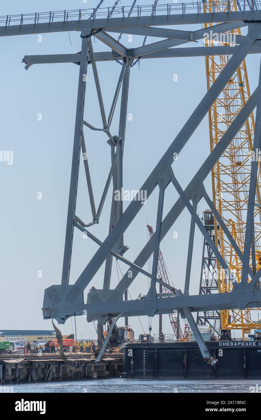 Key Bridge Response 2024 i salvatori dello Unified Command utilizzano la chiatta con gru Chesapeake 1000 per spostare un grande pezzo di acciaio di supporto dal crollo di Francis Scott Key Bridge, 14 aprile 2024, a Baltimora, Maryland. La Chesapeake 1000 è la più grande gru galleggiante sulla costa orientale, e la rimozione di questi grandi pezzi aiuterà ad aprire un canale ad accesso limitato che consente il traffico di navi a senso unico verso il porto di Baltimora. La rimozione di detriti e rottami è in corso a sostegno di una priorità assoluta per aprire in modo sicuro ed efficiente il canale di Fort McHenry. (Foto U.S. Army Corps of Engineers di Charles del Foto Stock