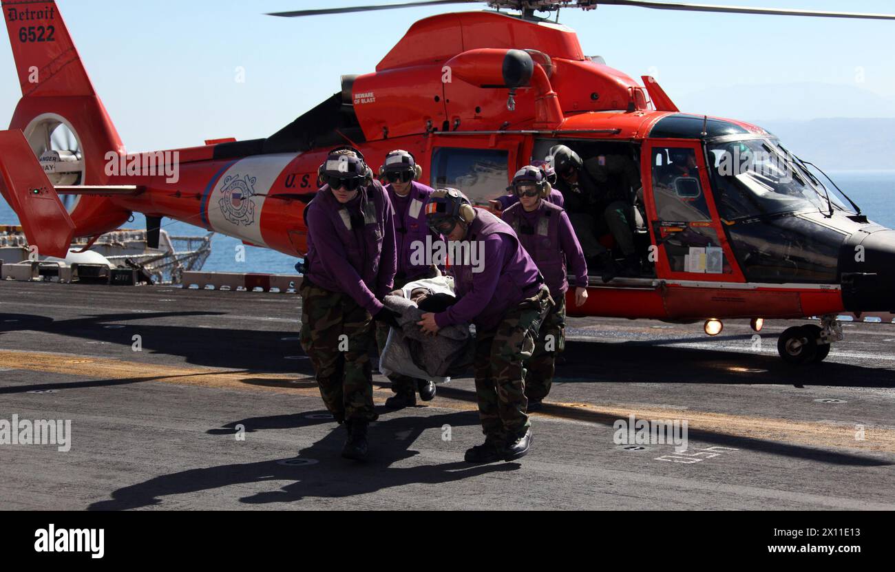 I membri dell'equipaggio della cabina di volo della Marina trasportano una vittima del terremoto haitiano nelle strutture mediche della nave d'assalto anfibia USS Bataan 21 gennaio 2010. La 22nd Marine Expeditionary Force è schierata con il Bataan Amphibious Readiness Group come parte della Unified Response al paese colpito dal terremoto di Haiti. Foto Stock