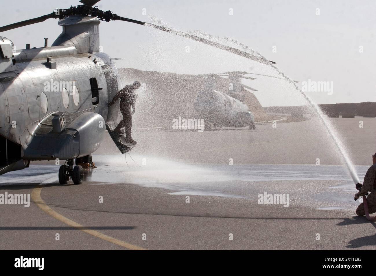 Il colonnello James o'Meara, l'ufficiale comandante del Marine Aircraft Group 26 (rinforzato), viene spruzzato con una manichetta antincendio mentre smonta uno degli elicotteri Marine Medium Helicopter Squadron 364 CH-46 Sea Knight a bordo della Asad Air base, Iraq, 16 gennaio 2010. Foto Stock