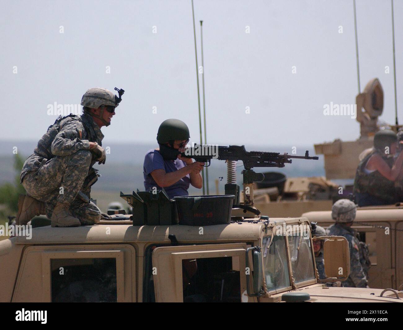 Il sergente Michael o'Neil, uno scout con Headquarters and Headquarters Company, 1st Brigade, 8th Combined Arms Battalion, 3rd Brigade Combat Team, 4th Infantry Division, mostra a una donna come sparare la mitragliatrice M-249 durante una dimostrazione di fuoco dal vivo a Fort Carson, Coloc. CA. 17 luglio 2007 per metadati Foto Stock