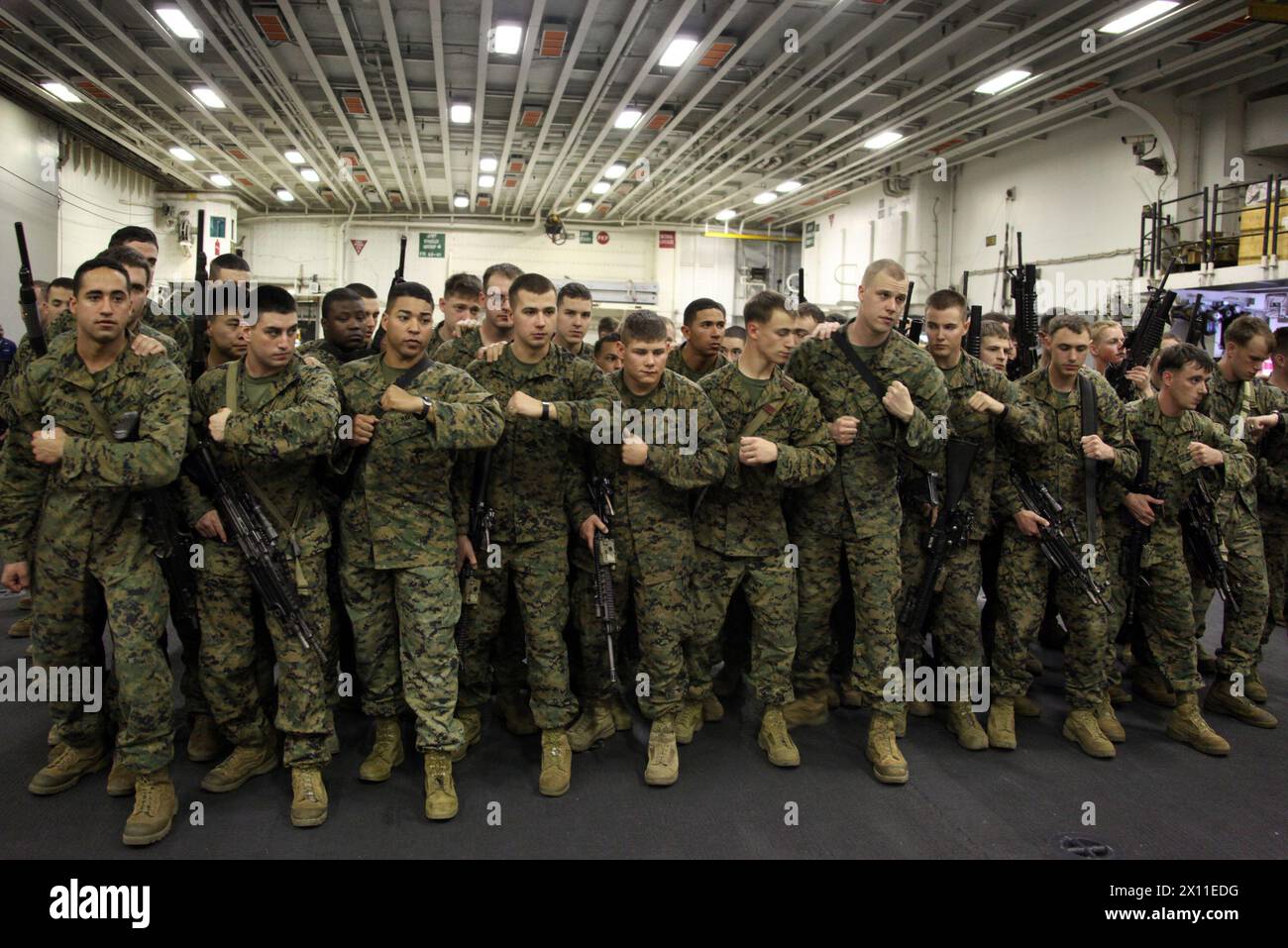 I Marines della compagnia L, Battalion Landing Team, 3rd Battalion, 2nd Marine Regiment, 22nd Marine Expeditionary Unit, esercitano l'uso di scudi antisommossa in stretta formazione, mentre sono a bordo della USS Bataan, 17 gennaio 2010. I Marines sono stati addestrati per le possibili situazioni che potevano incontrare prima di dirigersi ad Haiti per sostenere l'operazione Unified Response. Foto Stock