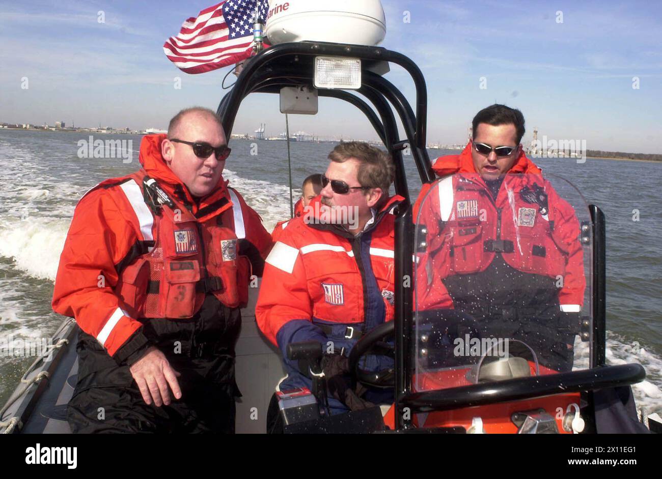 Il pilota NASCAR Terry Labonte prende il timone di uno dei gommoni a scafo rigido della Guardia Costiera oggi nel porto di Charleston. Boatswain's Mate 1st Class Charles Lynch (a sinistra) e Boatswains Mate 3rd Class Chris Crockett aiutano Labonte a mettere la barca OTH a velocità superiori a 40 nodi CA. 21 gennaio 2004 Foto Stock