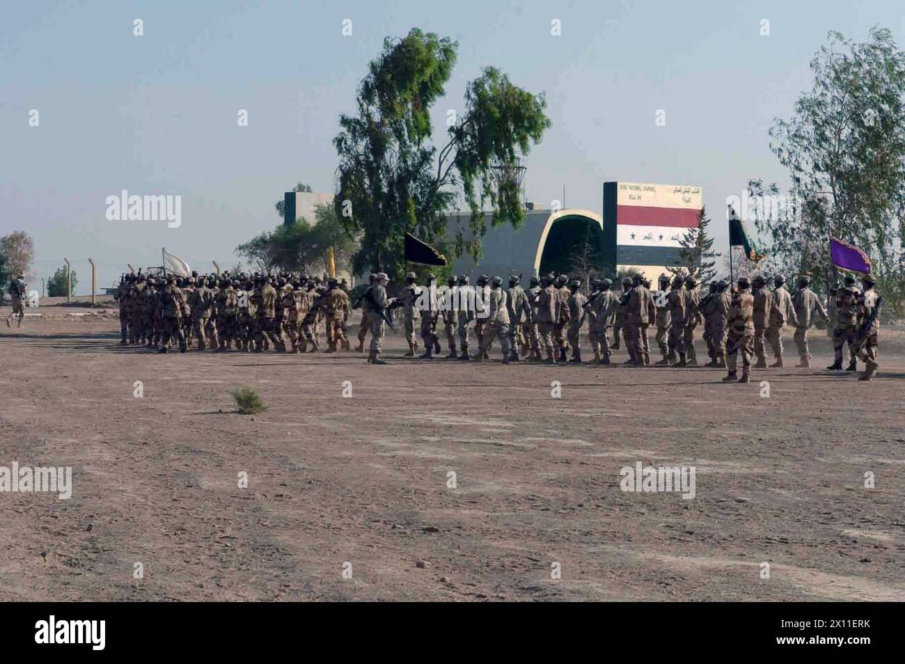 I soldati della Guardia Nazionale irachena si allontanano dalla cerimonia di laurea di base, fiduciosi e preparati a fornire sicurezza nella regione di Quyarrah, Iraq. I soldati parteciparono a un corso di addestramento di base di quattro settimane tenuto da soldati della compagnia C, 52nd Infantry Regiment, 3rd Brigade, 2nd Infantry Division (Stryker Brigade Combat Team) CA. 26 agosto 2004 Foto Stock