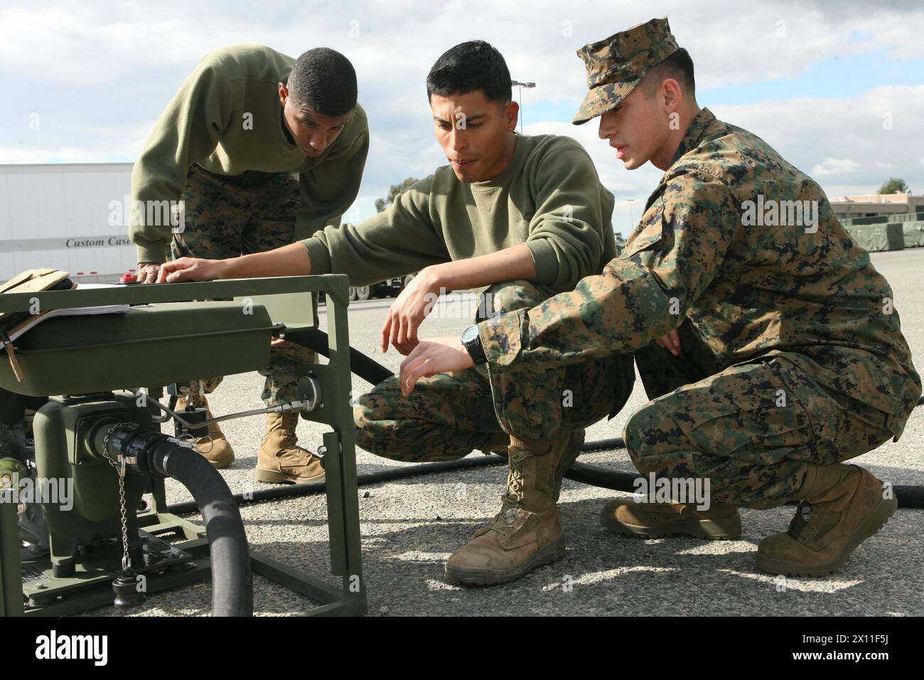 CPL. Jason R. Garris-Obrien (a sinistra), Lance Cpl. Jose R. Sebastian e Sgt. Carlos I. Salazar (a destra), operatori di attrezzature igieniche con 1st Marine Logistics Group, test a Lightweight Water Purification System a Camp Pendleton, California, 27 gennaio 2010. Il nuovo sistema di purificazione dell'acqua consente ai Marines di purificare l'acqua in movimento, poiché pesa un quarto rispetto al vecchio sistema. Foto Stock