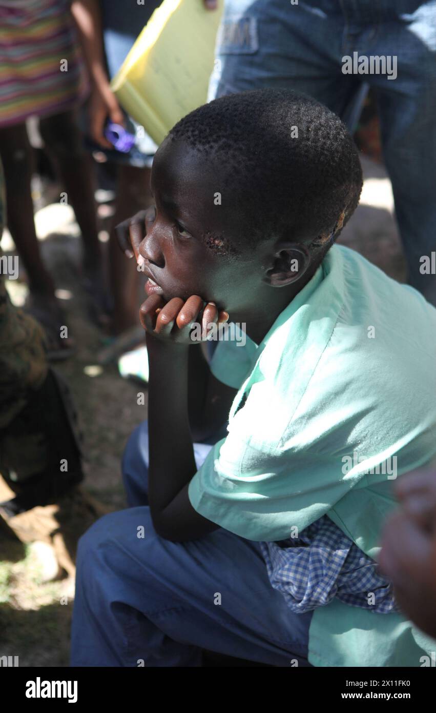 Un ragazzo haitiano attende di essere visto dai soldati del Battalion Leading Team, 3rd Battalion, 2nd Marine Regiment, 22nd Marine Expeditionary Unit, durante una missione medica a Dano, Haiti, 28 gennaio 2010. Foto Stock