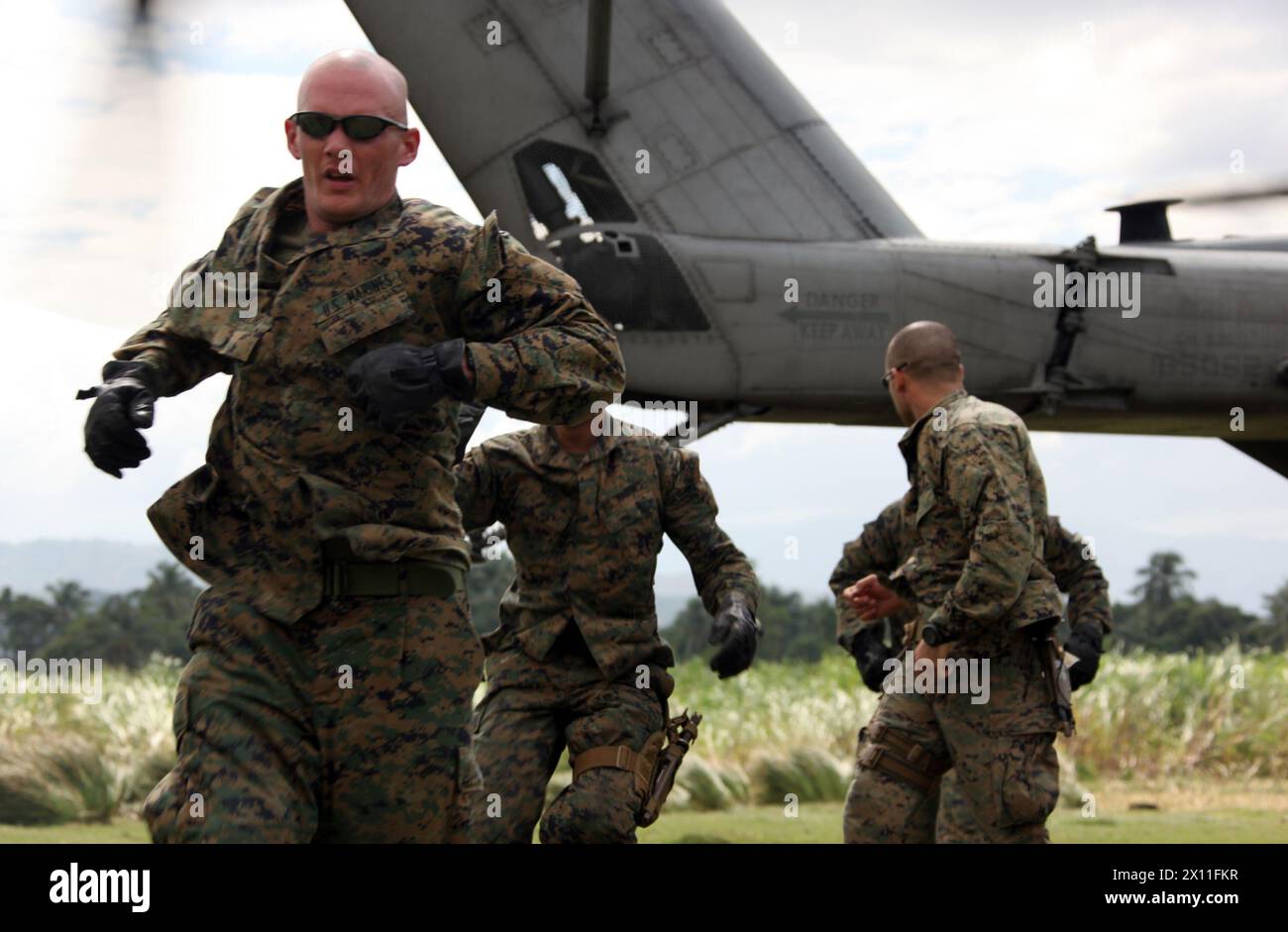 I Marines della Lima Company, Battalion Landing Team, 3rd Battalion, 2nd Marine Regiment, 22nd Marine Expeditionary Unit, si allontanano da un CH-53E Super Stallion con Marine Heavy Helicopter Squadron 461 (rinforzato), 22nd MEU, mentre si prepara a partire da una zona di atterraggio a Leogane, Haiti, 25 gennaio 2010. Foto Stock