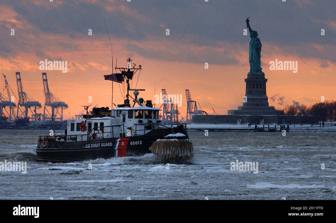 Il Coast Guard Cutter Wire, un rimorchiatore di ghiaccio di 65 piedi, portato in casa a Saugerties, N.Y., si fa strada attraverso un flusso di ghiaccio nel porto di New York il 28 gennaio 2004. Foto Stock