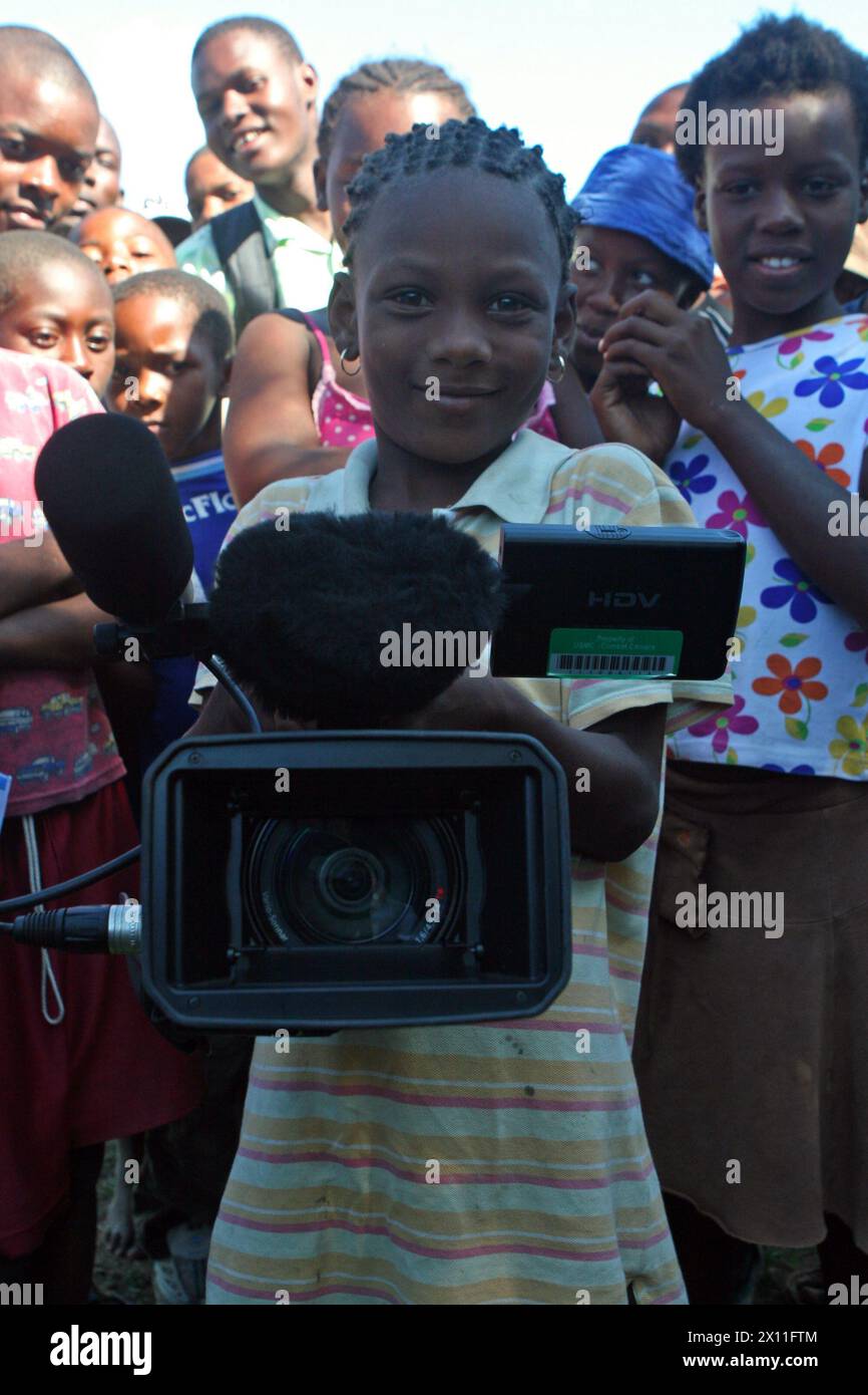 Un bambino di Cotes De Fer, Haiti, gioca con una videocamera in un punto di distribuzione temporanea degli aiuti, 21 gennaio 2010. I Marines e i marinai del 22° MEU hanno istituito un punto temporaneo di distribuzione delle forniture di soccorso nei pressi di Cotes de Fer, Haiti, portando acqua in bottiglia e cibo da distribuire agli haitiani sfollati interni. Il 22° MEU, imbarcato a bordo delle navi della Bataan Amphibious Ready Mission, è schierato a sostegno delle operazioni di soccorso ad Haiti. Foto Stock