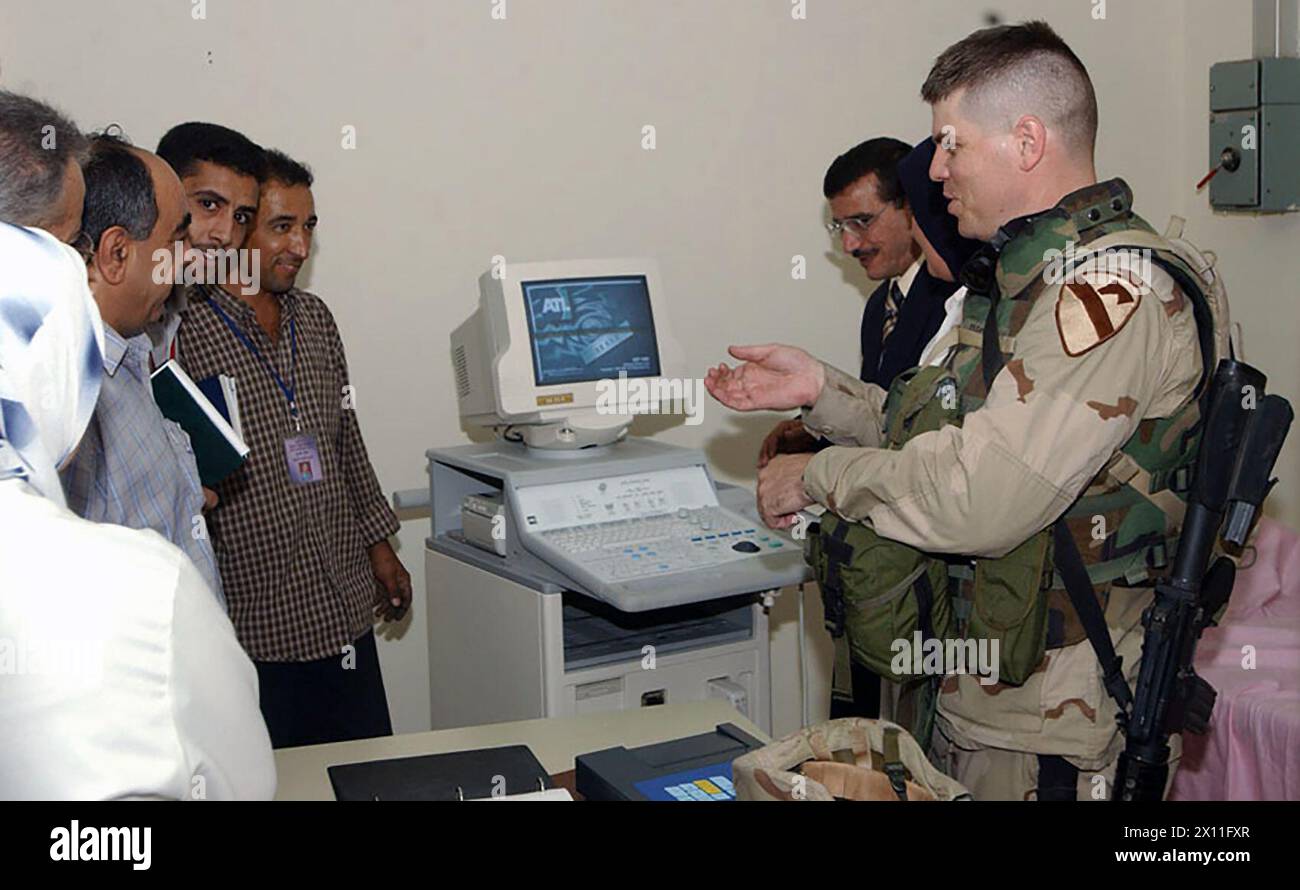 Il maggiore Richard Bickel, chirurgo di brigata della 1st Brigade Combat Team della 1st Cavalry Division, aiuta il personale dell'Habi Bija Obstetrics-Ginecology and Pediatrics Hospital a eseguire controlli pre-operativi su una nuova macchina sonar a ultrasuoni CA. 15 luglio 2004 Foto Stock