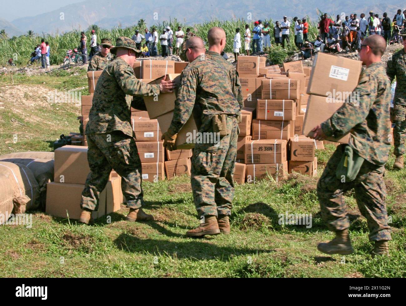 Marines della Lima Company, Battalion Landing Team, 3rd Battalion, 2nd Marine Regiment, 22nd Marine Expeditionary Unit, stack supplies a Leogane, Haiti, 22 gennaio 2010. I 22 MEU hanno fornito generi alimentari e forniture a sostegno dell'assistenza umanitaria e delle operazioni di soccorso per le vittime del terremoto del 12 gennaio. Foto Stock