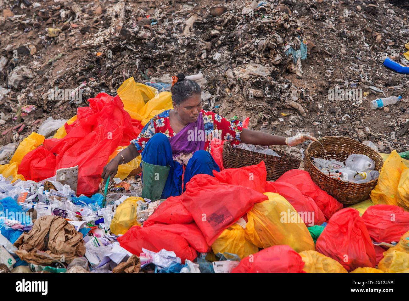 Questa donna sta separando la plastica da una spazzatura. Foto Stock