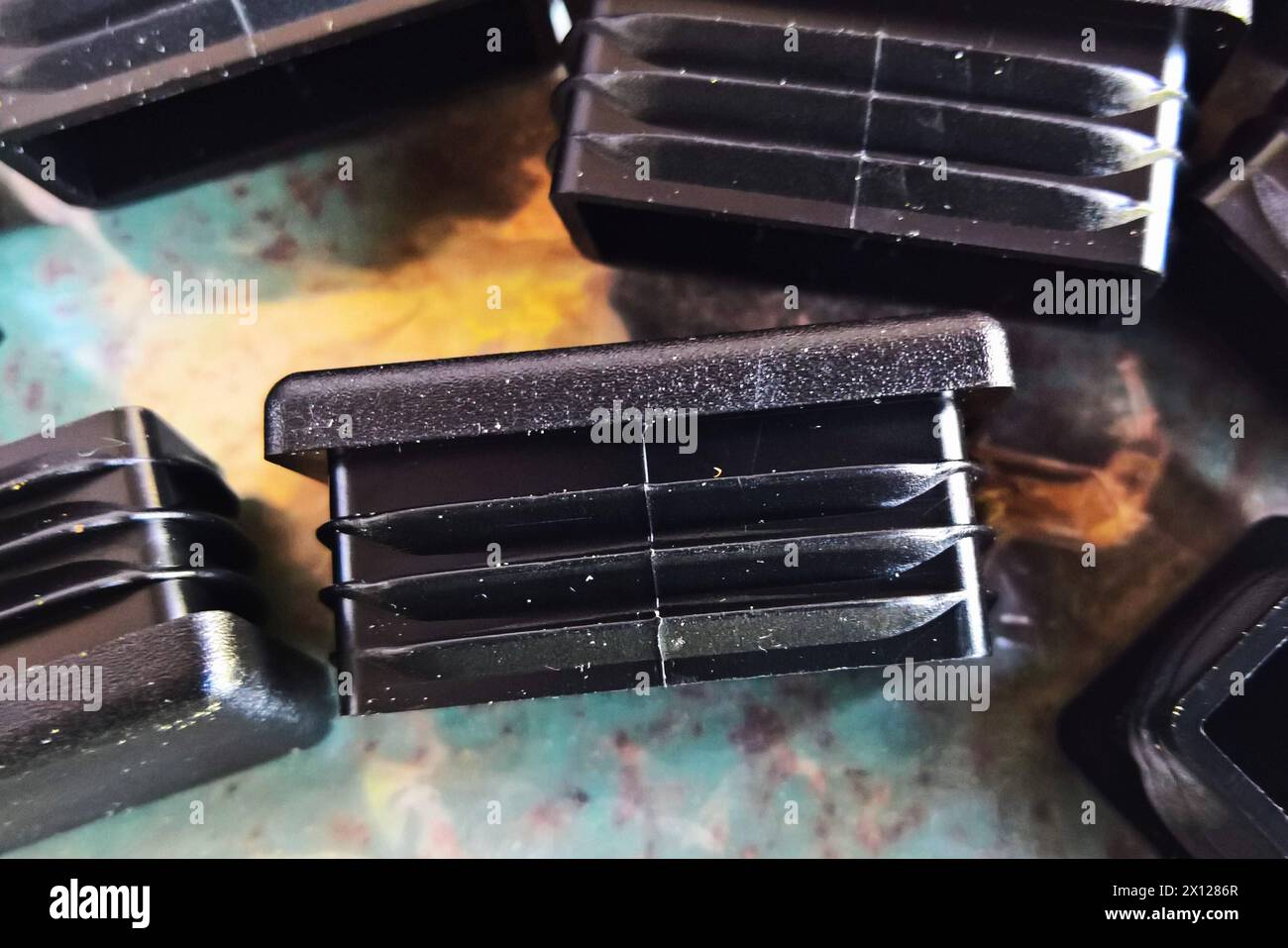 Plastik - Rohrkappe bzw Abdeckkappe rechteckig aus Kunstoff. Stuhlgleiter, auch Möbelgleiter oder Filzgleiter Schützen Parkett-, Laminat- oder andere empfindliche Böden vor Gebrauchsspuren durch das Verrücken von Möbeln wie Stühlen, Tischen oder Schränken *** cappuccio tubolare in plastica o cappuccio rettangolare in plastica piedini per sedie, noti anche come piedini per mobili o piedini in feltro, proteggere il parquet, laminato o altri pavimenti sensibili dovuti a segni di usura causati dal movimento di mobili come sedie, tavoli o armadi Foto Stock