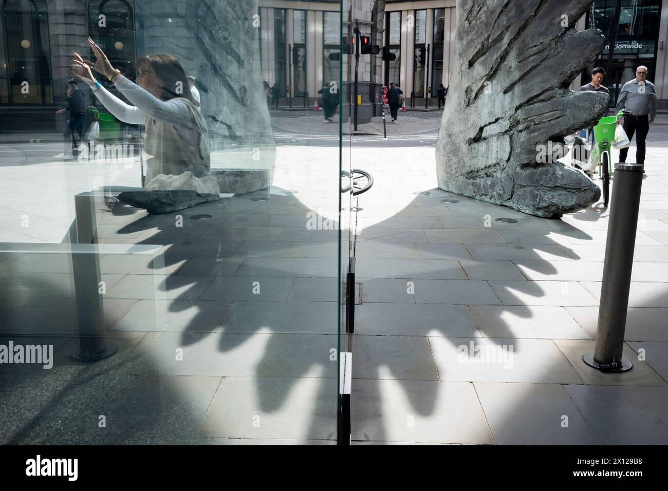 Operai dell'industria finanziaria e la scultura intitolata "City Wing" su Threadneedle Street nella City di Londra, il quartiere finanziario della capitale (aka The Square Mile), il 14 aprile 2024, a Londra, Inghilterra. City Wing è dell'artista Christopher le Brun. La scultura in bronzo alta dieci metri è opera del presidente della Royal Academy of Arts, Christopher le Brun, commissionata da Hammerson nel 2009. Si chiama ‘The City Wing’ ed è stata fusa dai Morris Singer Art Founders, ritenuti la più antica fonderia di belle arti del mondo. Foto Stock