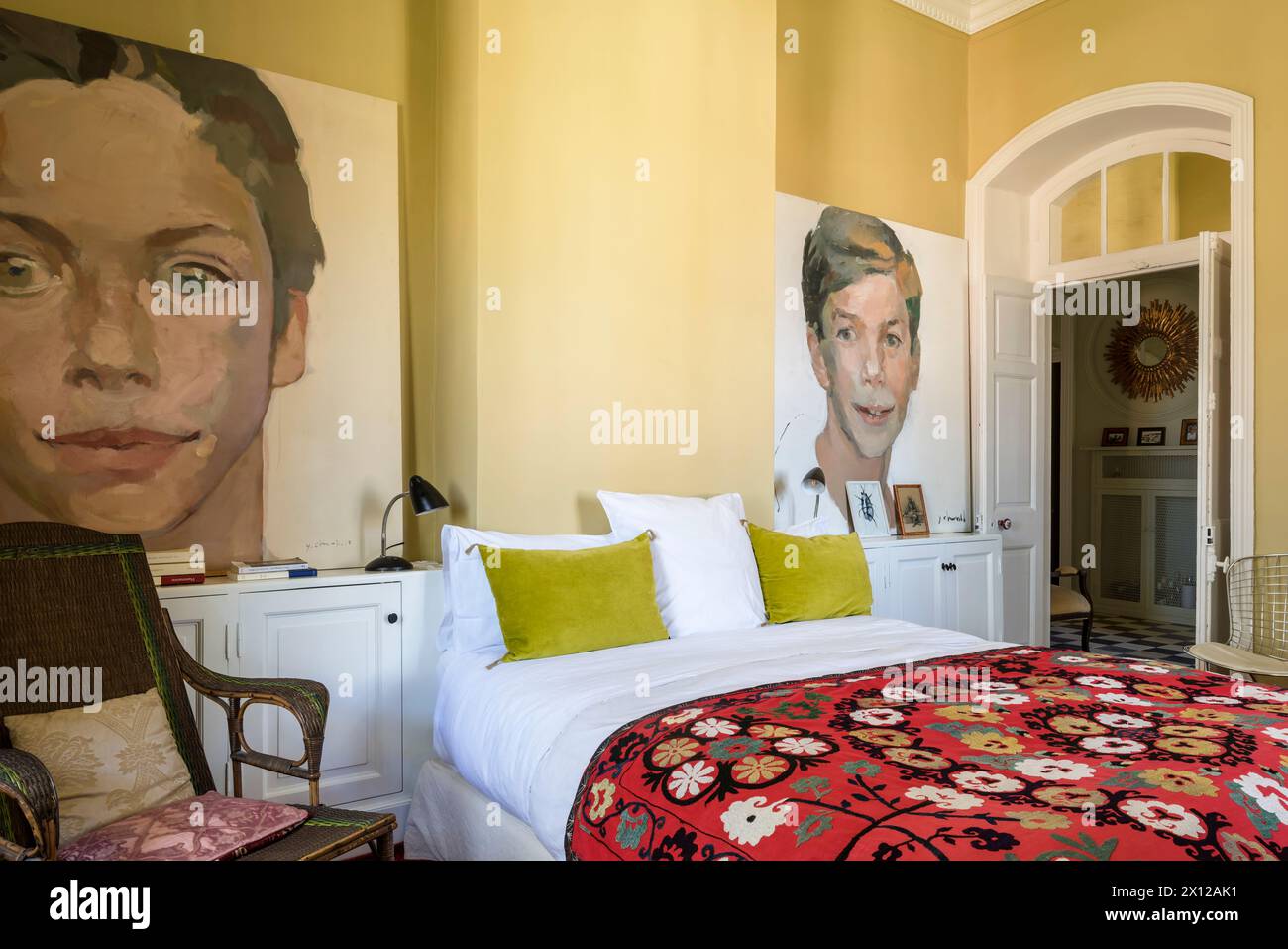 Copriletto floreale e grandi ritratti nella camera da letto di Mimi Calpe, villa di lusso francese degli anni '1950 e hotel a Tangeri, Marocco Foto Stock