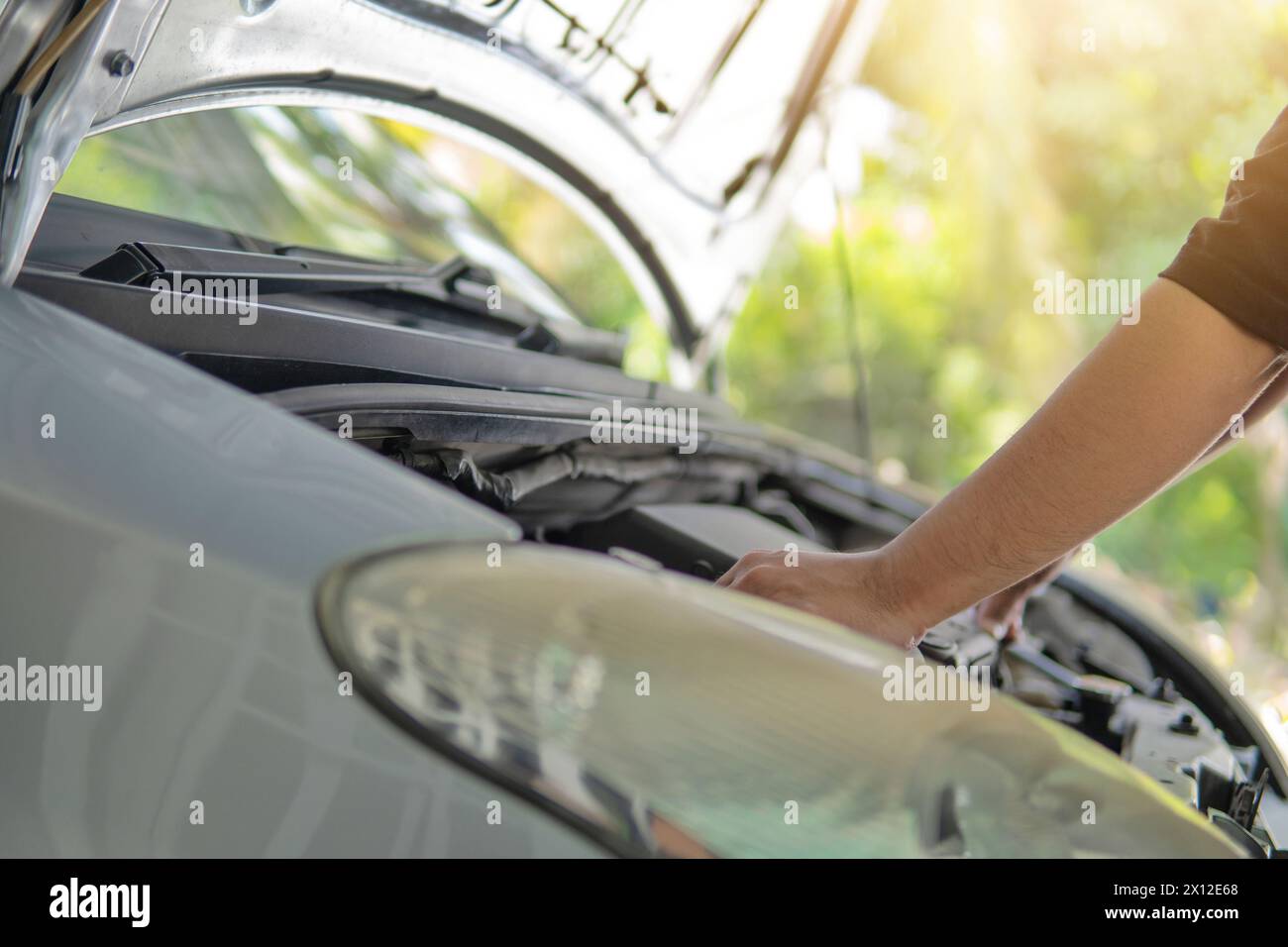 Immagine ravvicinata di un uomo che ispeziona e controlla il motore dell'auto. Concetto di trasporto. Foto Stock